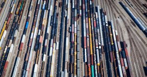 Overhead view of a rail yard with long, colorful lines of rail cars.