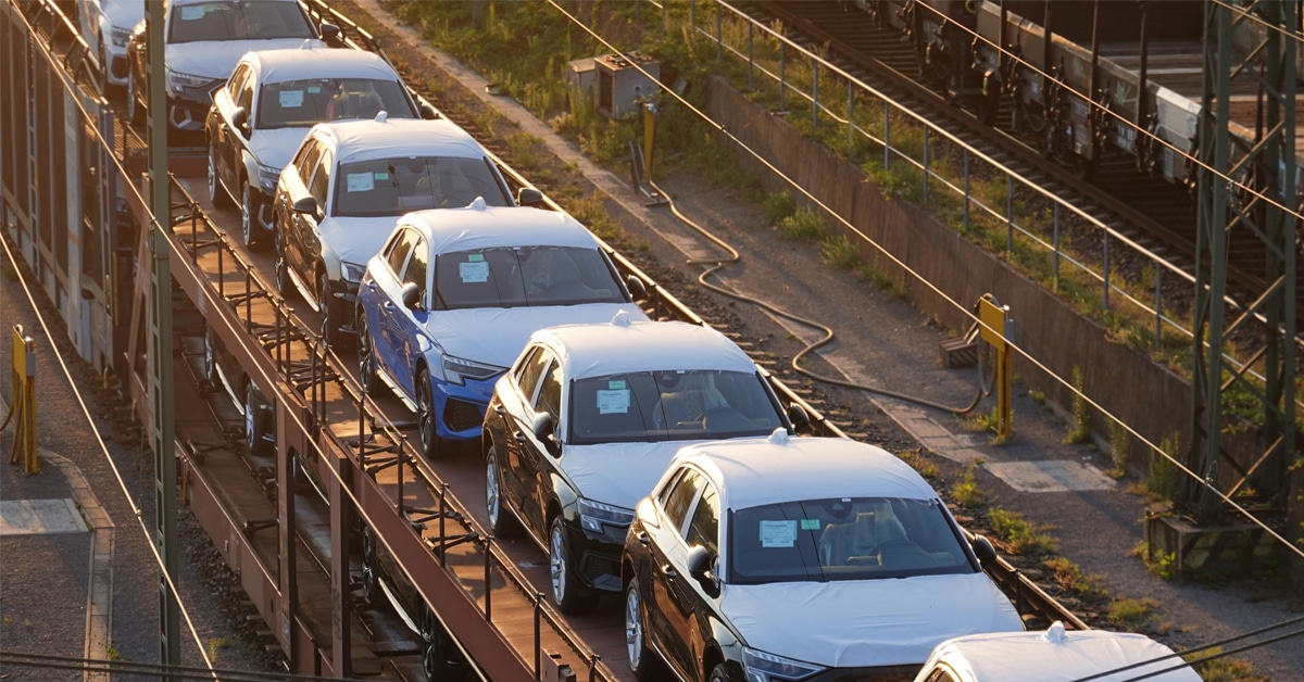An example of one of the railcar types, a line of new black and white automobiles on top of an autorack rail car.