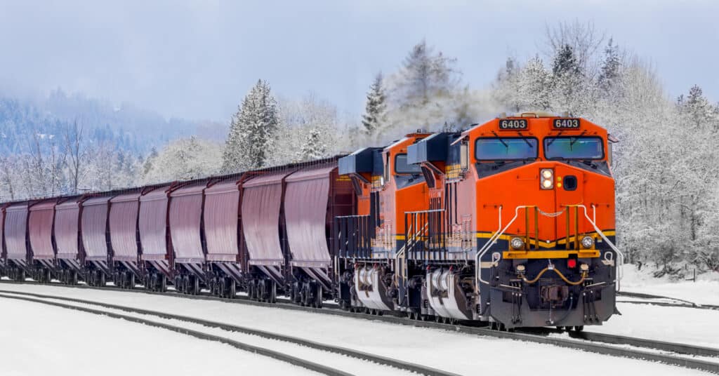 Winter scene of a locomotive pulling a freight train.